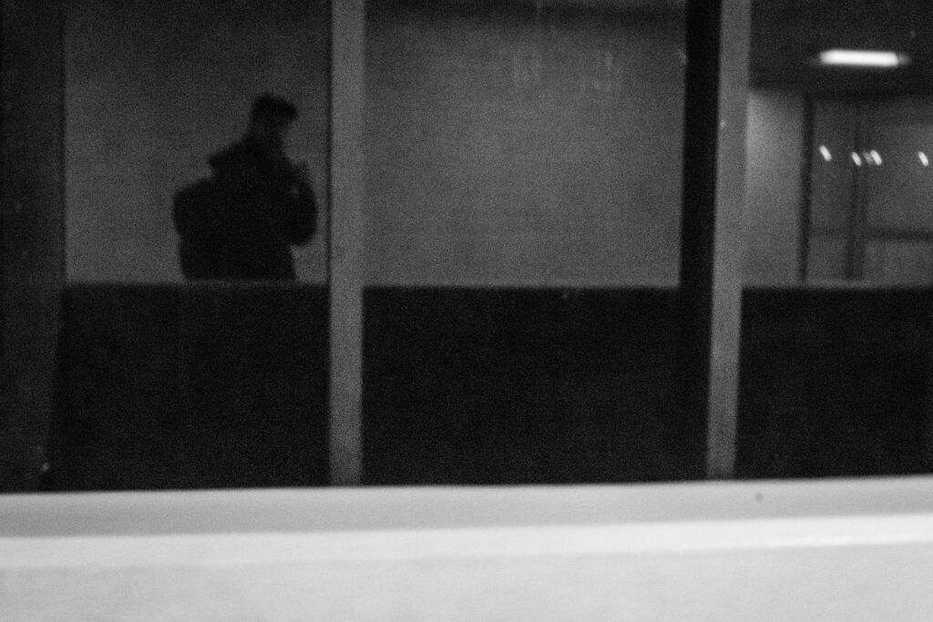 A photo I took of my self, on a dark reflection surface, in some subway of NYC. 